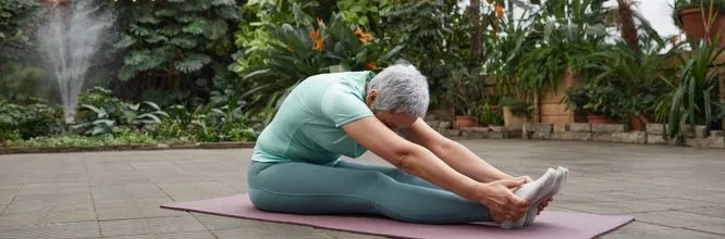 Senior lady facendo stretching in un giardino botanico